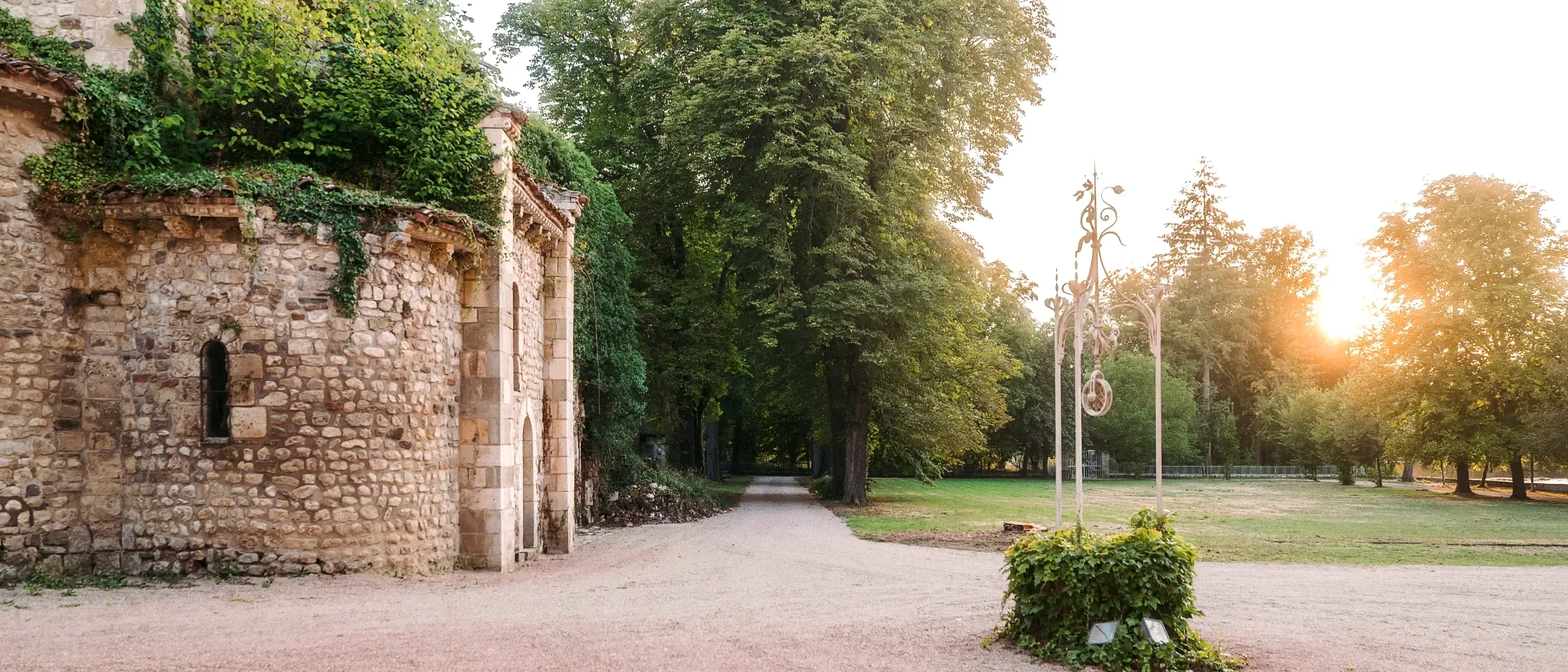 La cour du château, la chapelle et l'allée du parc au soleil couchant