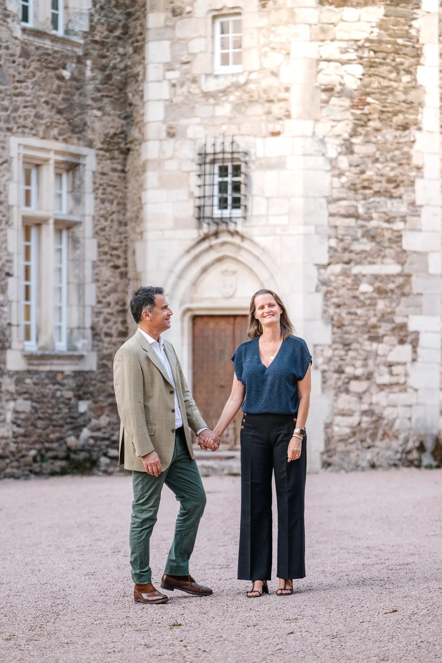 Les propriétaires devant la porte du château, main dans la main