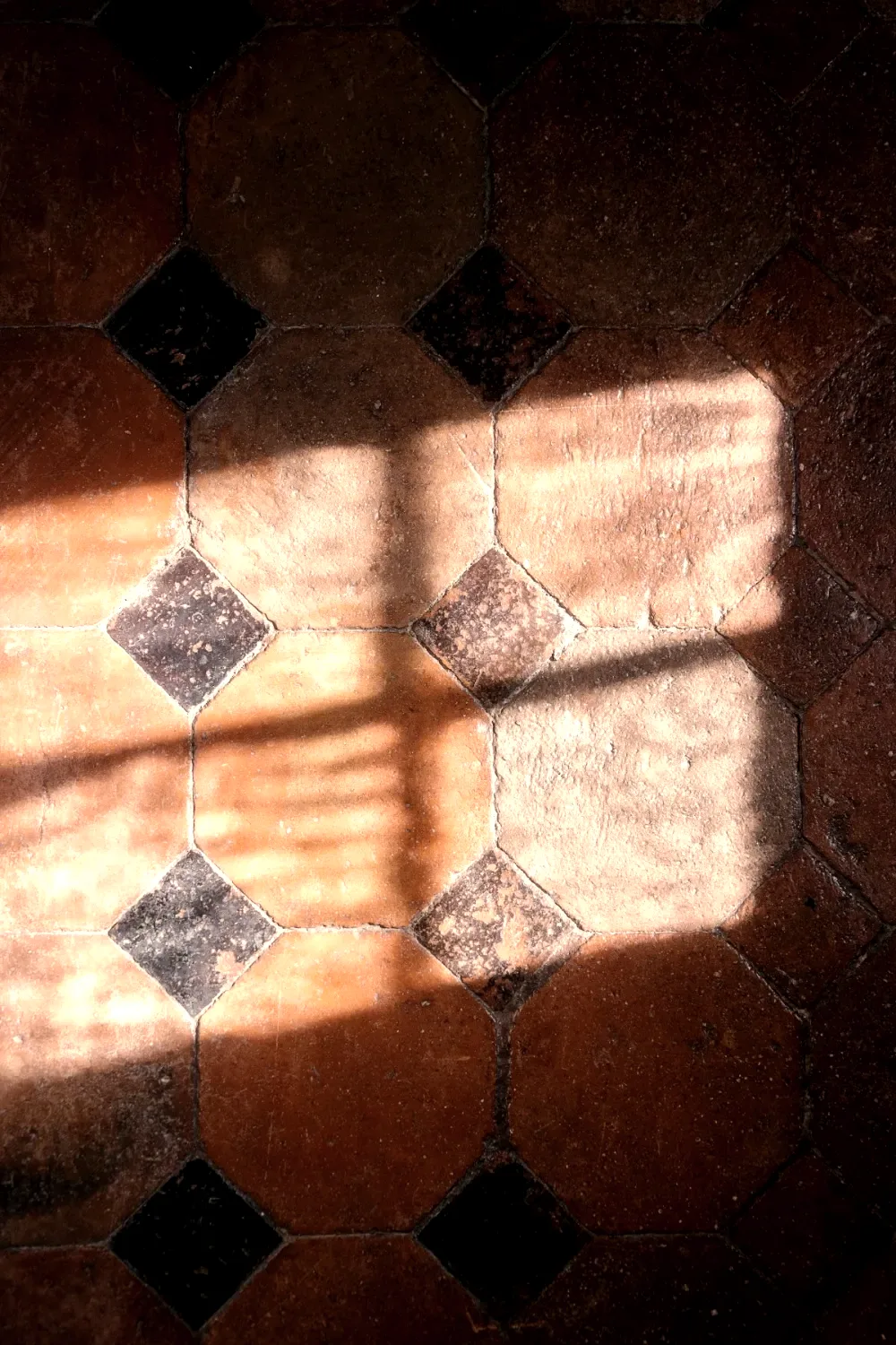 Tomettes anciennes et lumière de fenêtre au sol